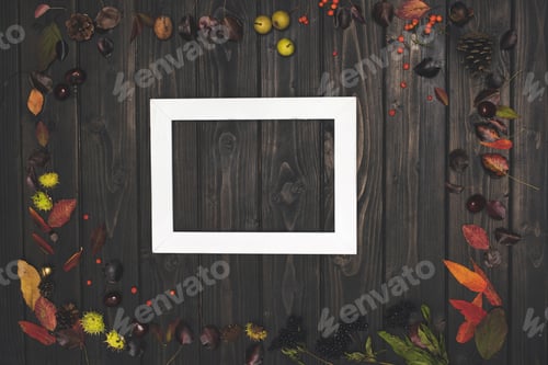 Preview: top view of beautiful autumn composition and white frame on wooden surface