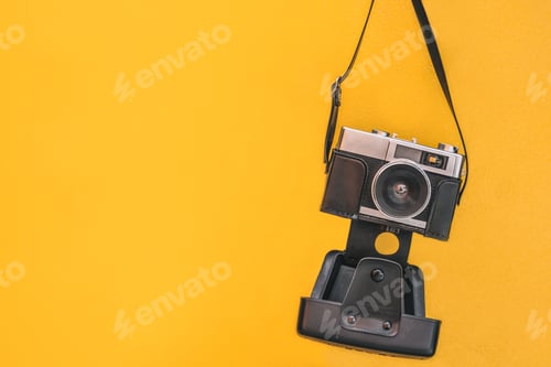 Preview: Vintage camera isolated at orange wall