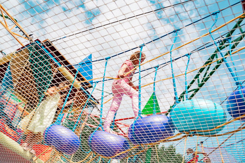 Preview: Small children have fun in rope amusement park. Suspended rides on top. Obstacle course, ladder, ste