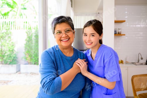 Preview: Doctor or nurse caregiver with senior patient at home or nursing home, Female doctor visiting