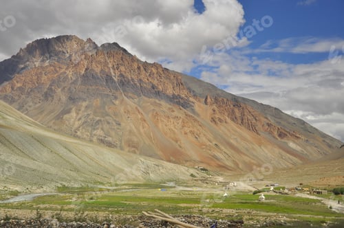 Preview: View of a beautiful rocky mountain with clouds in sky and flowing a river