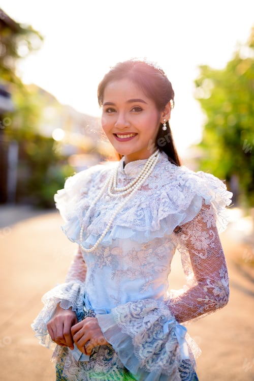 Preview: Young beautiful Asian woman wearing Thai traditional clothes outdoors