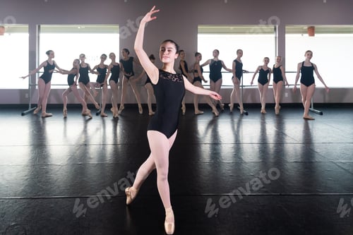 Preview: Teenage girl in ballet dance studio poses with the rest of the class behind her