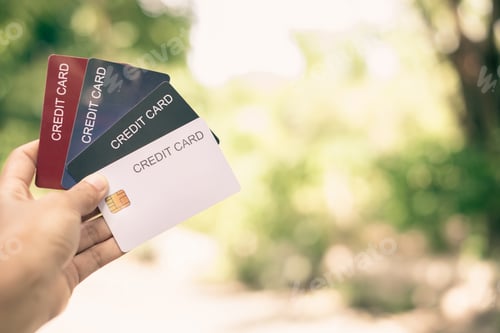 Preview: Credit Card. hand holding credit card with green nature background