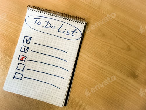 Preview: to do list checklist hand written on notepad paper lay on wooden table.