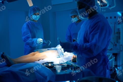 Preview: Surgeons performing surgical procedure in modern operating theater
