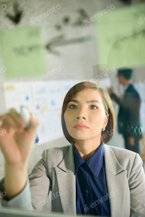 Preview: Business lady writing on glass wall