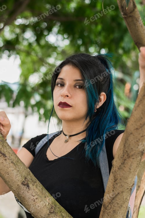 Preview: Latin college girl with blue hair walking through the park dressed in black and blue bag
