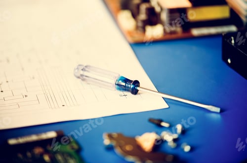 Preview: Closeup of screwdriver over circuit pattern guide line paper