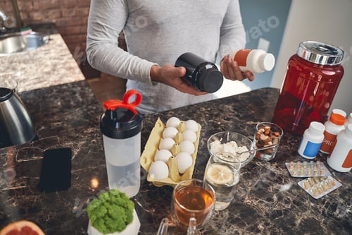 Preview: Sportsman with sports nutrition at the table