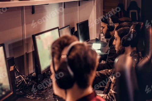 Preview: Team of teenage gamers plays in a multiplayer video game on pc in a gaming club.