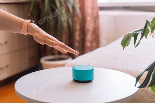 Preview: A woman's hand touches a blue smart speaker on the table