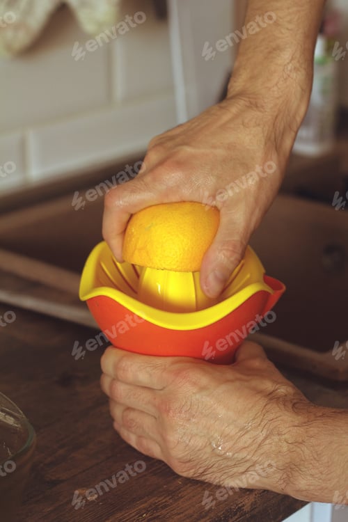 Preview: man squeezes orange juice close up