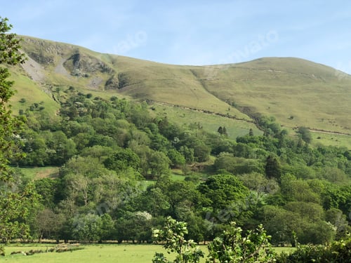 Preview: Scenic view of a lush green grassy field with majestic mountains in the background.
