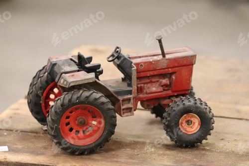 Preview: Closeup shot of an old red tractor toy displayed in a garage sale