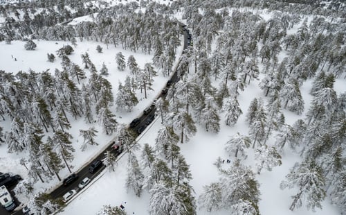 Preview: Drone aerial scenery of highway road crossing the snowy mountain forest landscape in winte