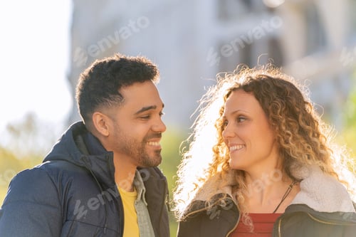Preview: Happy multi ethnic couple smiling and sharing a romantic moment outdoors