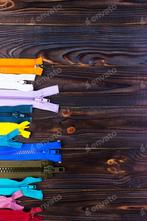 Preview: different colorful zippers in front of wood background