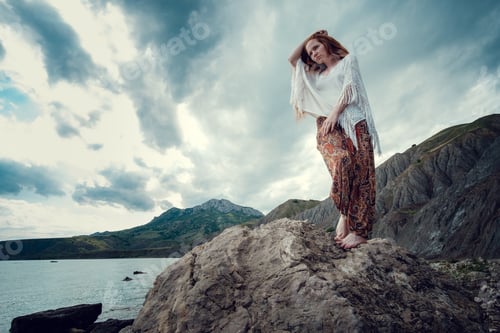 Preview: Beautiful boho styled model wearing white crochet swimsuit posing on the beach in sunlight