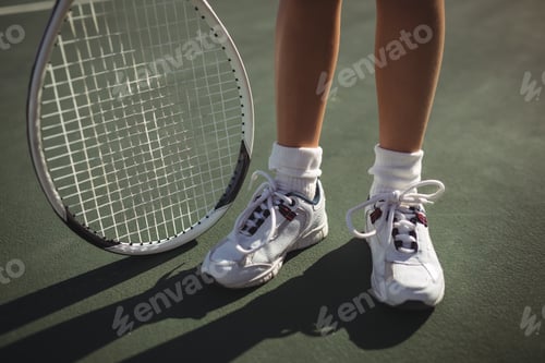 Preview: Low section of girl with tennis racket