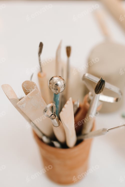 Preview: Collection of clay sculpting tools. Black apron artisan grips set of potters instruments