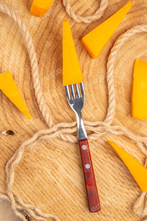 Preview: top view cheese on fork slices of cheese and rope on wooden ground