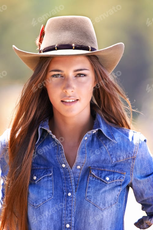Preview: Wild at heart. An attractive young cowgirl standing in the stables.