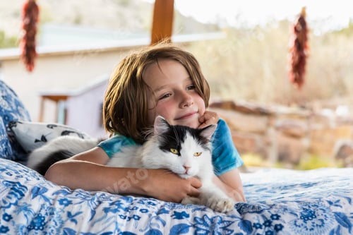 Preview: Child Cuddling White and Black Cat Indoors