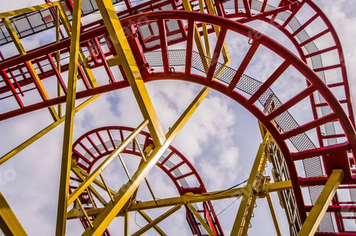 Preview: Low angle shot of a roller coaster ride with a cloudy sky in the background