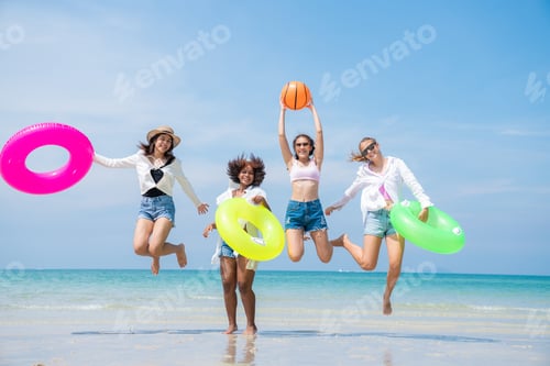 Preview: Group of teenage with floaty on the beach having fun.