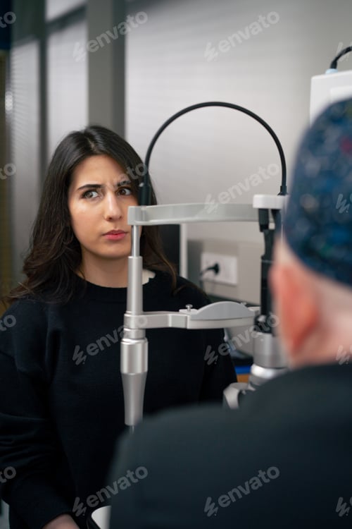 Preview: in an ophthalmology clinic old doctor conducts a consultation about vision with a young girl