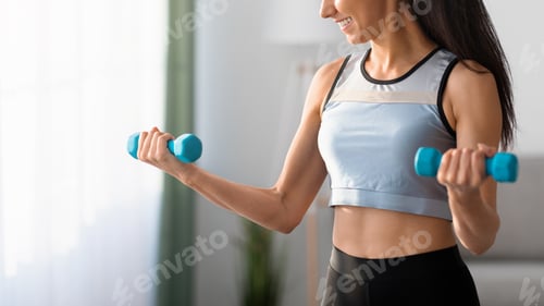 Preview: Cropped of sporty woman lifting blue dumbbells