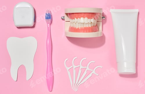 Preview: White tube of toothpaste, pink toothbrush, dental floss, plastic floss holders