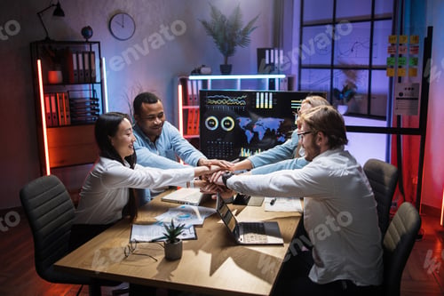 Preview: Multiracial partners stacking hands together after meeting