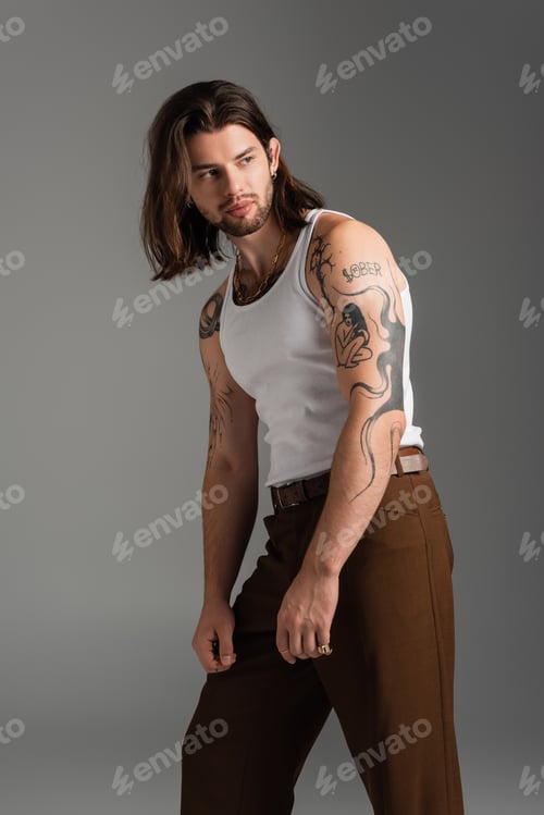 Preview: Fashionable and tattooed model in white tank top isolated on grey