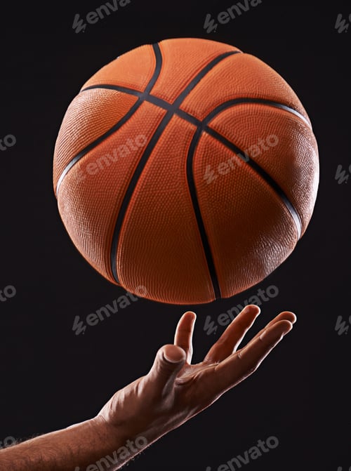 Preview: Cropped image of a mans hand holding a basketball against a black background