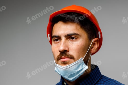 Retrato de obrero de la construcción con máscara protectora sobre fondo gris