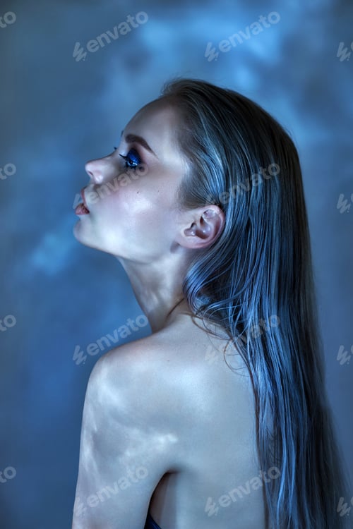 Preview: Woman with wet hair and bright makeup posing near the water, portrait. Glare from the water on the
