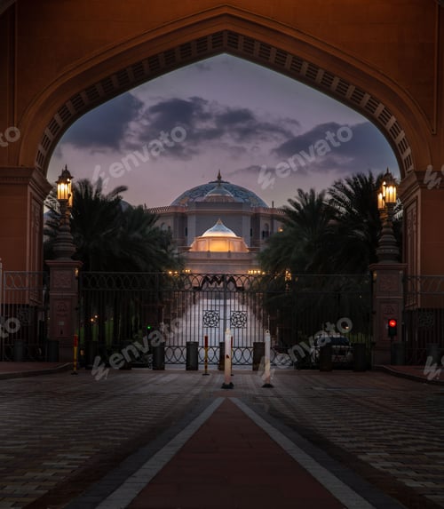 Preview: Road to a grand building through an arched gate at sunset