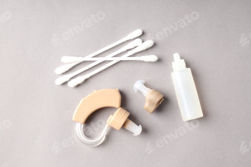 Preview: Concept of health care with hearing aid on gray background