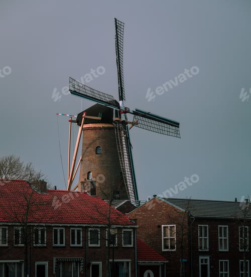 Preview: Aged windmill with red-tiled roofs and a clear blue sky in the background