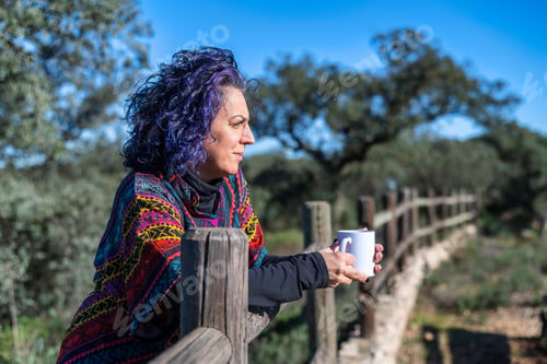 Preview: Mature woman enjoying freedom and nature with coffee