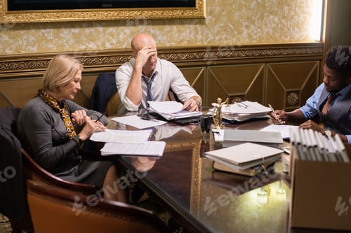 Preview: Group of contemporary co-workers working with documents