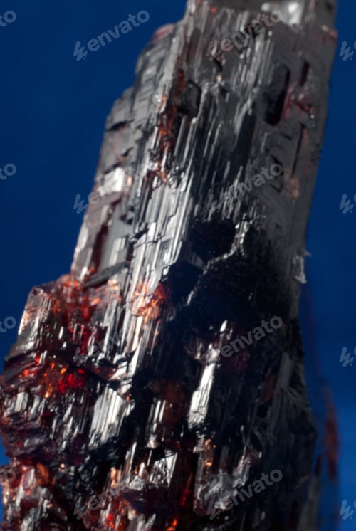 Preview: Vertical shot of a Spessartine mineral isolated on a blue background