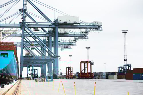 Preview: A massive cargo ship moored at the harbor while being loaded with containers