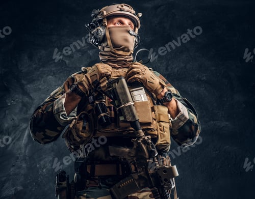 Preview: Special forces soldier in camouflage uniform holding an assault rifle with a laser sight