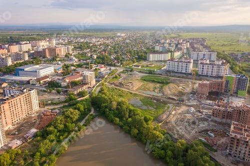 Preview: Top view of urban developing city landscape with tall apartment buildings and suburb houses.