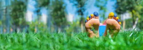 Preview: Child feet on the grass Ukrainian flag. Selective focus.