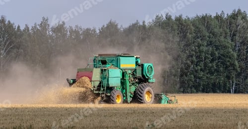 Preview: View of harvester cutting wheat, collecting grain