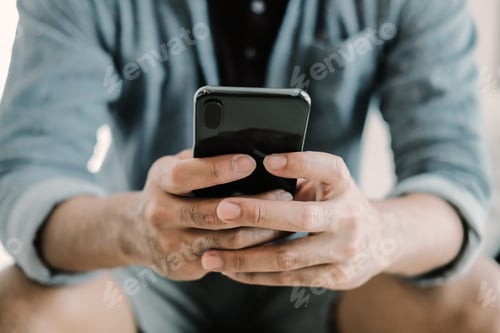 Preview: Close up man using smart phone at home